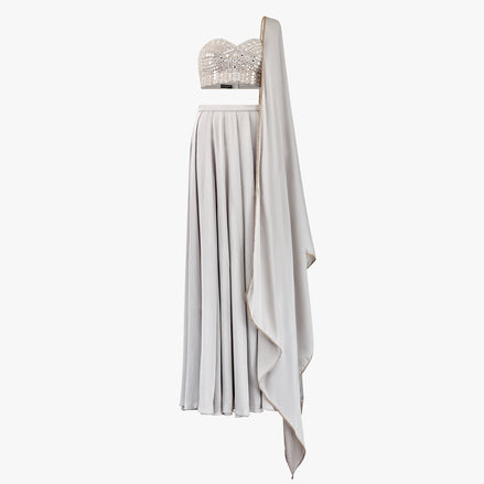 The Carlia lehenga set features a delicate mirror and chikan kari embellished bandeau top, Paired with a luxurious satin lehenga and matching dupatta, designed by Shenena Sethi