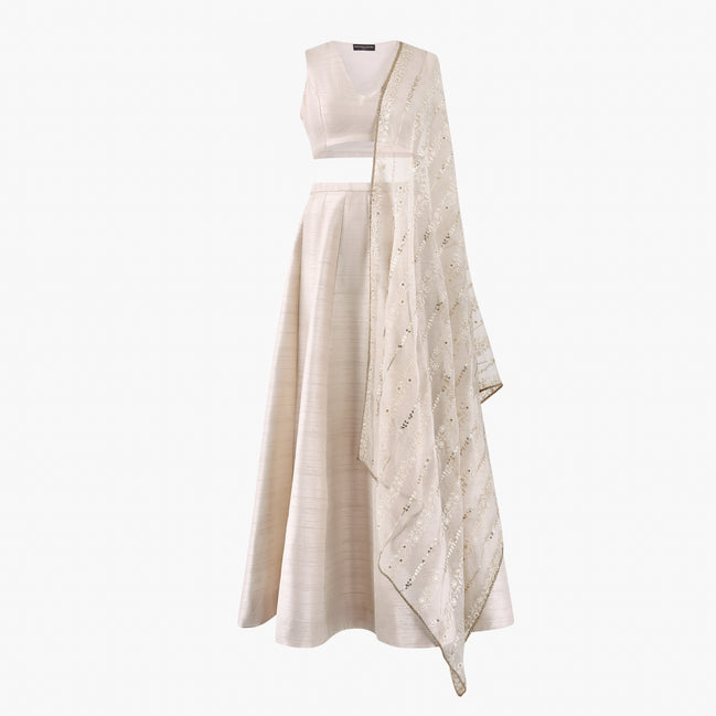 A cream-colored semi raw silk lehenga and top featuring an organza thread and sequin dupatta, designed by Shenena Sethi