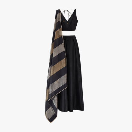 A traditional Indian semi raw silk lehenga and top paired with a chanderi tissue block dupatta in black, silver, and gold colours, designed by Shenena Sethi