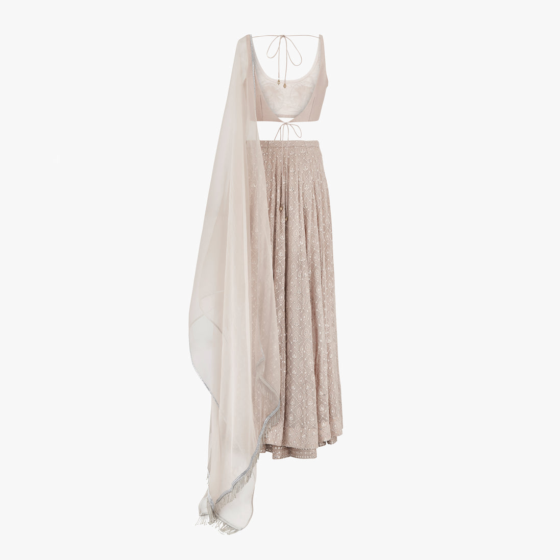 A nude pink chikan kari lehenga, semi raw silk top, accompanied by a soft pure organza dupatta with tassels on the ends, designed by Shenena Sethi