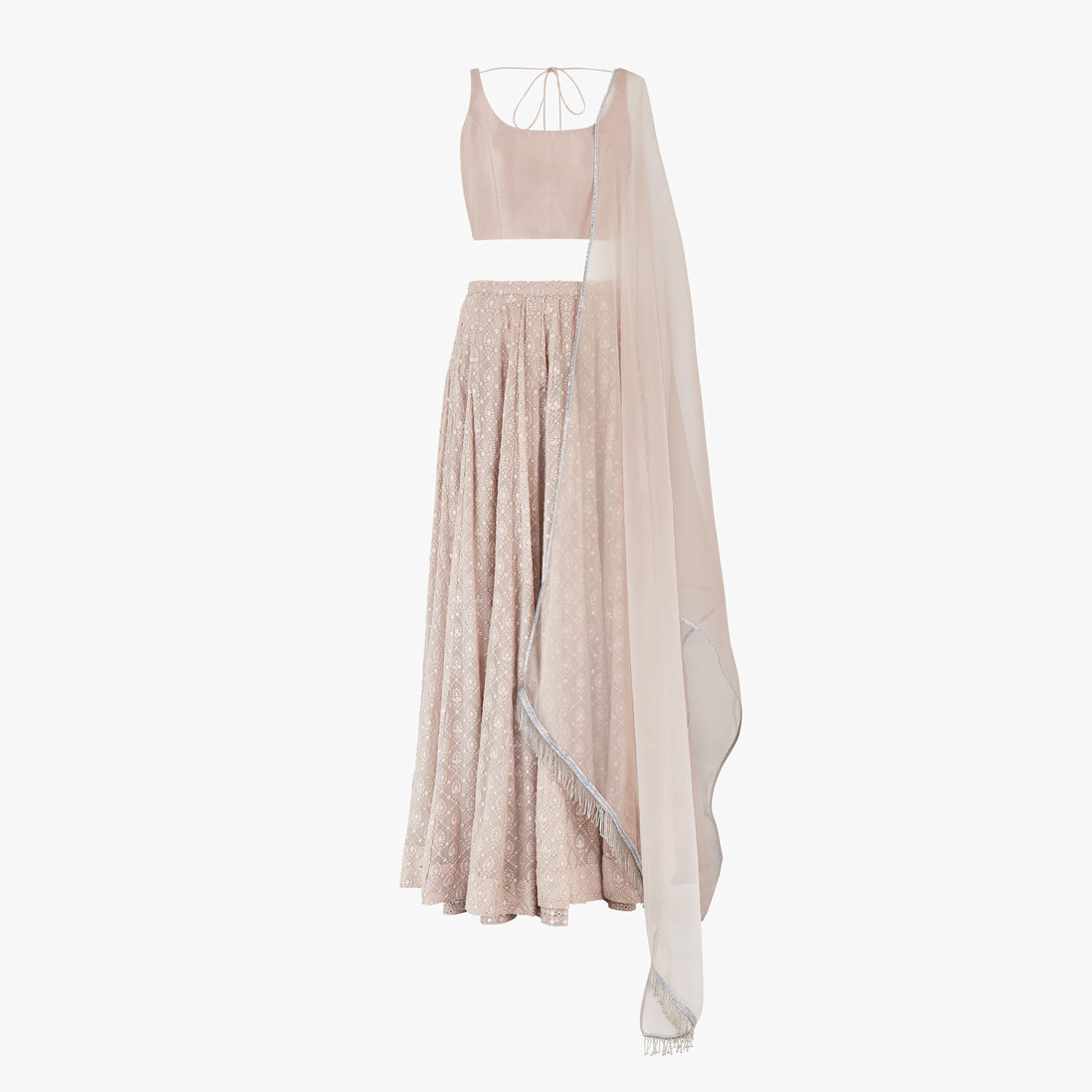 A nude pink chikan kari lehenga, semi raw silk top, accompanied by a soft pure organza dupatta with tassels on the ends, designed by Shenena Sethi