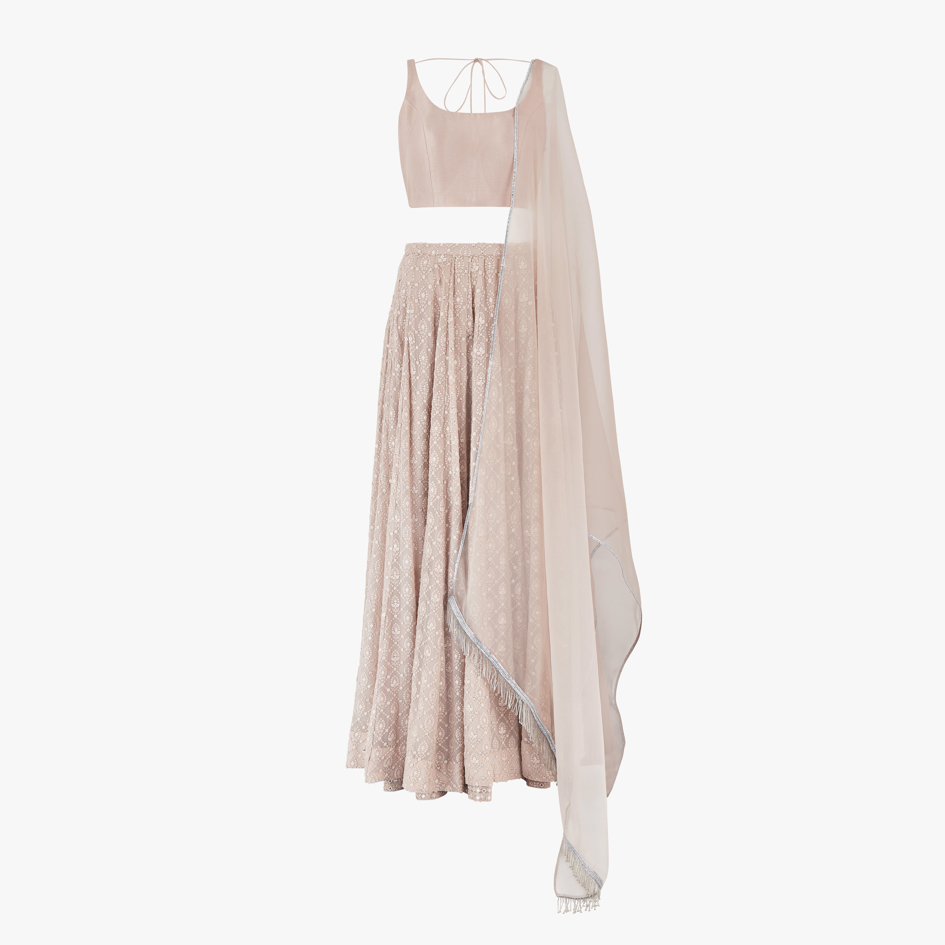 A nude pink chikan kari lehenga, semi raw silk top, accompanied by a soft pure organza dupatta with tassels on the ends, designed by Shenena Sethi