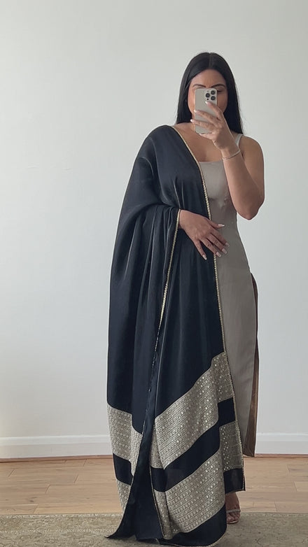 A luxury silk kameez in grey and black with a satin/silk dupatta featuring mirror work. The kameez is paired with a Lycra pajami, designed by Shenena Sethi