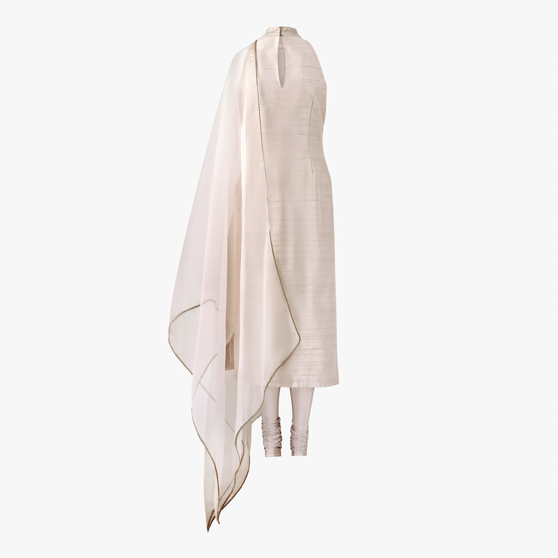 A cream-colored semi raw silk kameez with mirror embroidery along the front hem and collar, complemented by an organza dupatta with a gold border, designed by Shenena Sethi